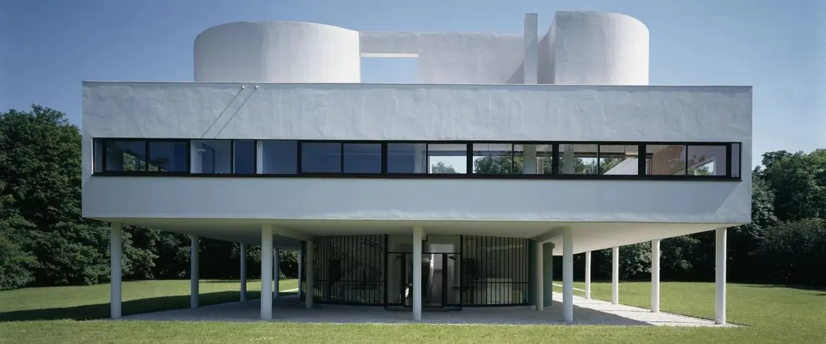 Photo d'une villa moderniste blanche sur pilotis, avec une fenêtre en bandeau
