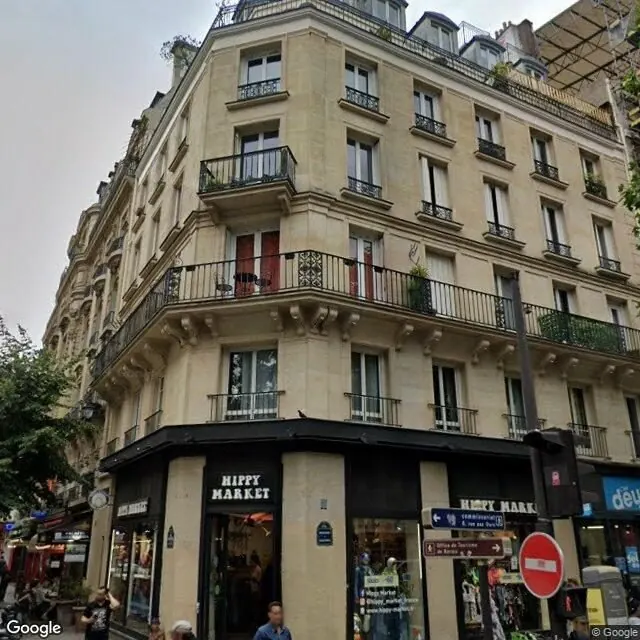 Vue Street View d'un immeuble haussmannien d'angle à Paris, avec un magasin au rez-de-chaussée